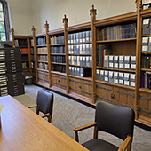 Archival boxes stacked behind a wooden table