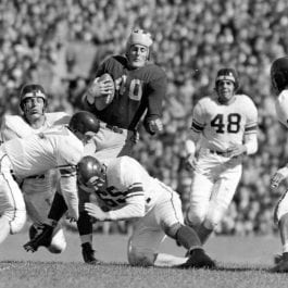 A black and white photo of a football player running towards the camera